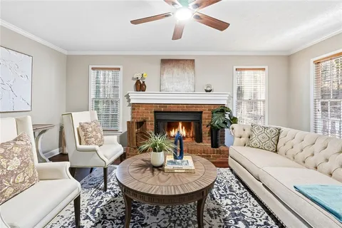 a living room with furniture a fireplace and a window