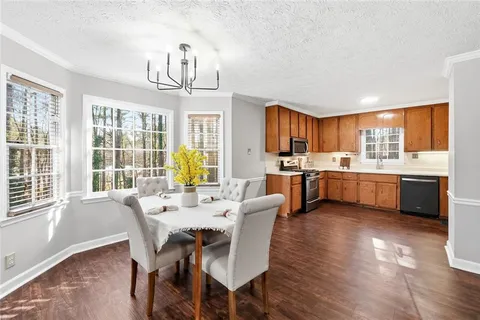 a view of a dining room with furniture a chandelier and wooden floor