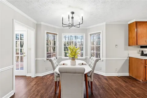 a view of a dining room with furniture a chandelier and wooden floor