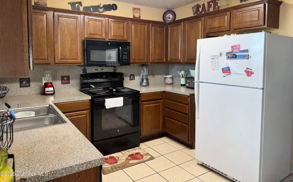 a kitchen with stainless steel appliances granite countertop a refrigerator sink stove and microwave