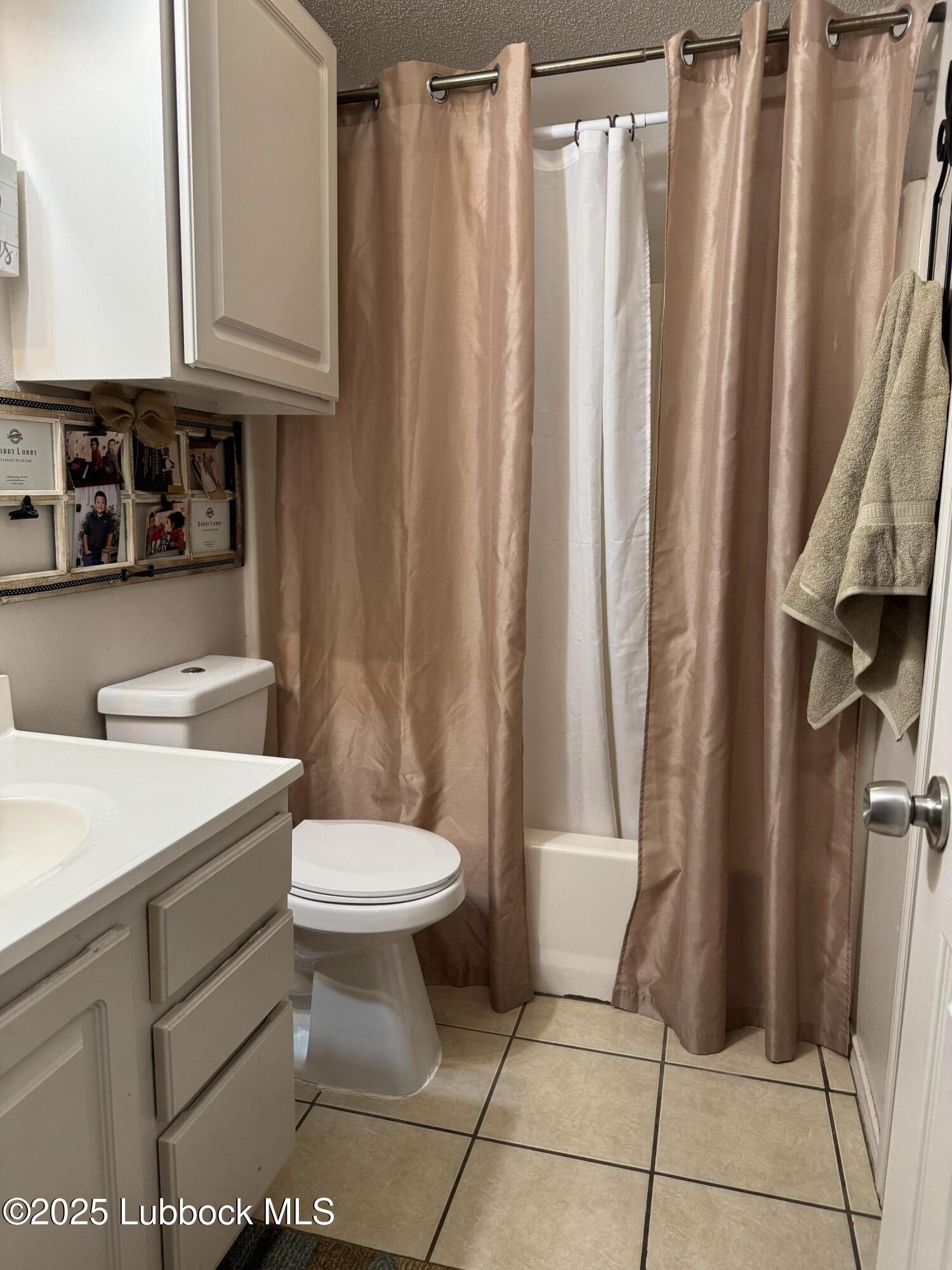 303 77th Street Lubbock, TX 79404 - Photo 5 of 9 a bathroom with a sink a toilet and shower