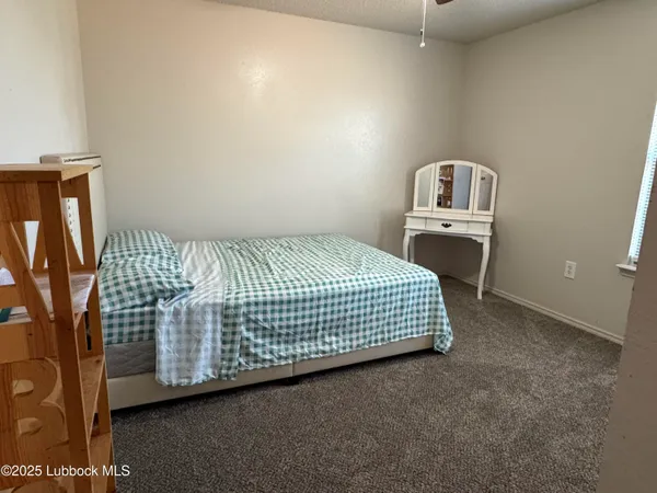 a bed sitting in a bedroom next to a lamp