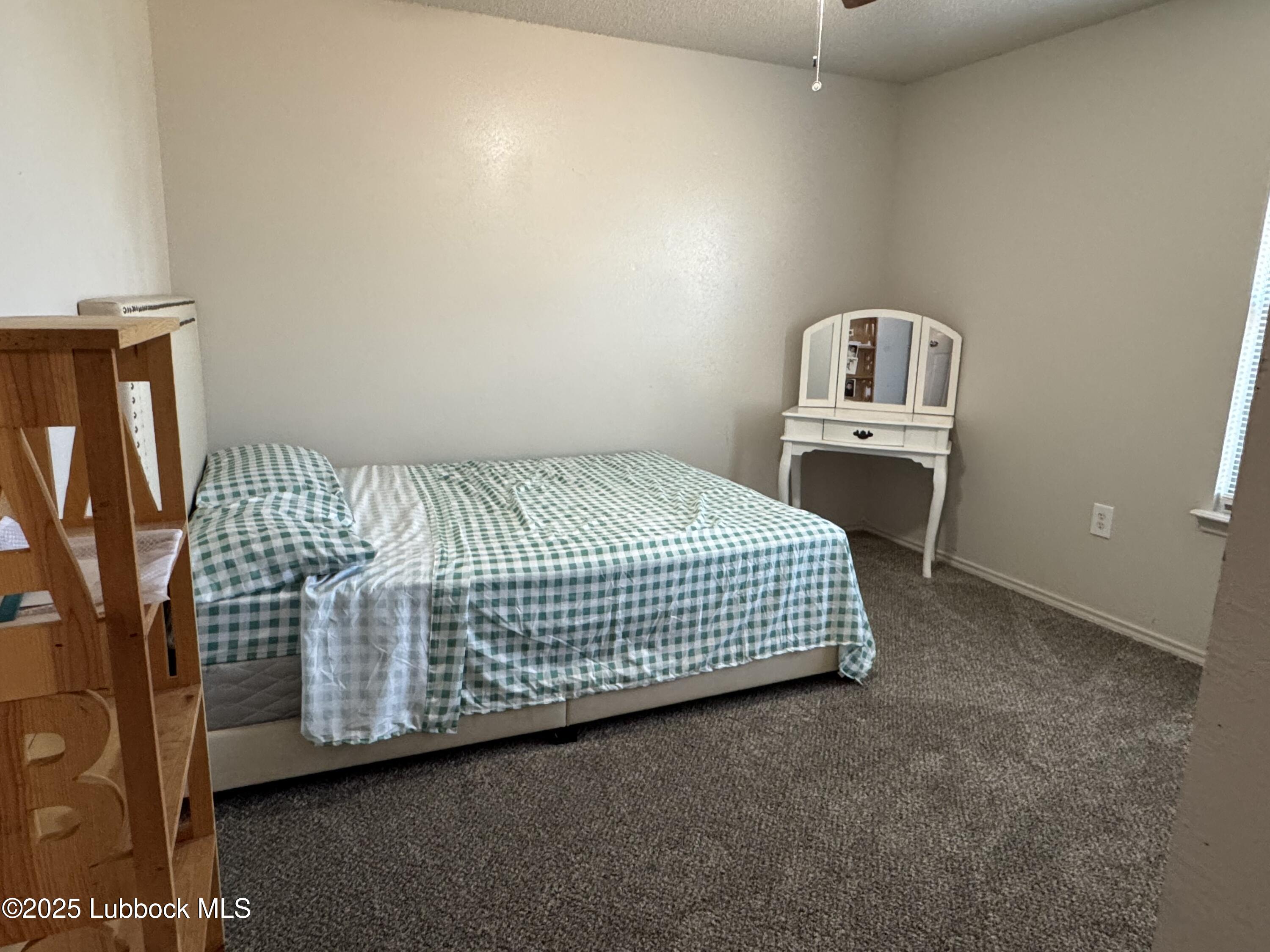 303 77th Street Lubbock, TX 79404 - Photo 7 of 9 a bed sitting in a bedroom next to a lamp