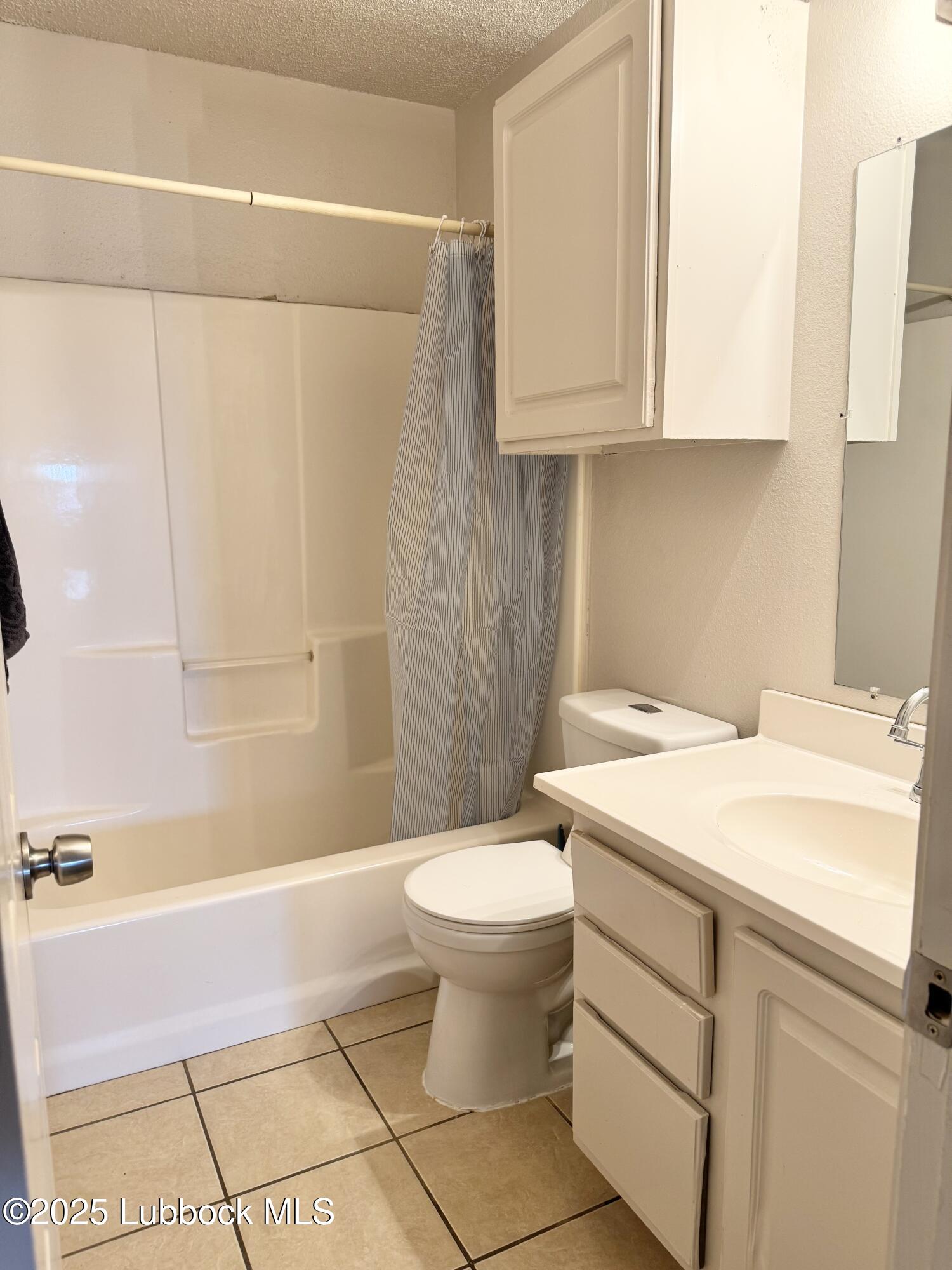 303 77th Street Lubbock, TX 79404 - Photo 8 of 9 a bathroom with a sink a toilet and shower