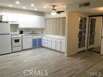 a kitchen with granite countertop a stove a sink and a refrigerator