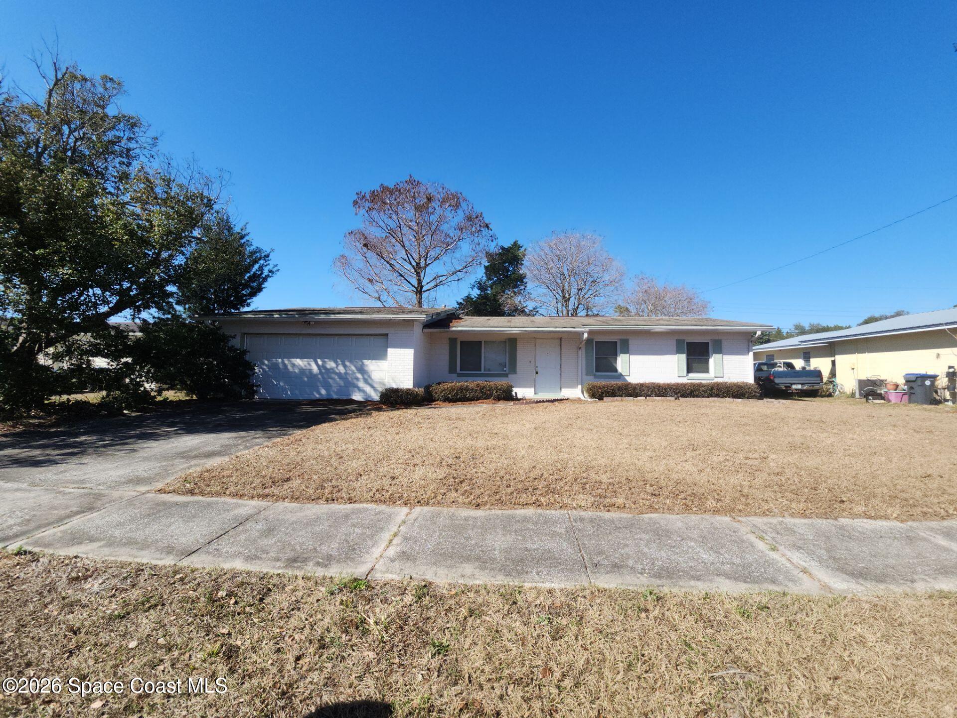 1654 Rice Avenue Titusville, FL 32796 - Photo 1 of 18 a front view of a house with a yard and garage