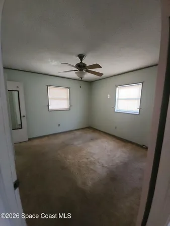 a view of a livingroom with a ceiling fan and window