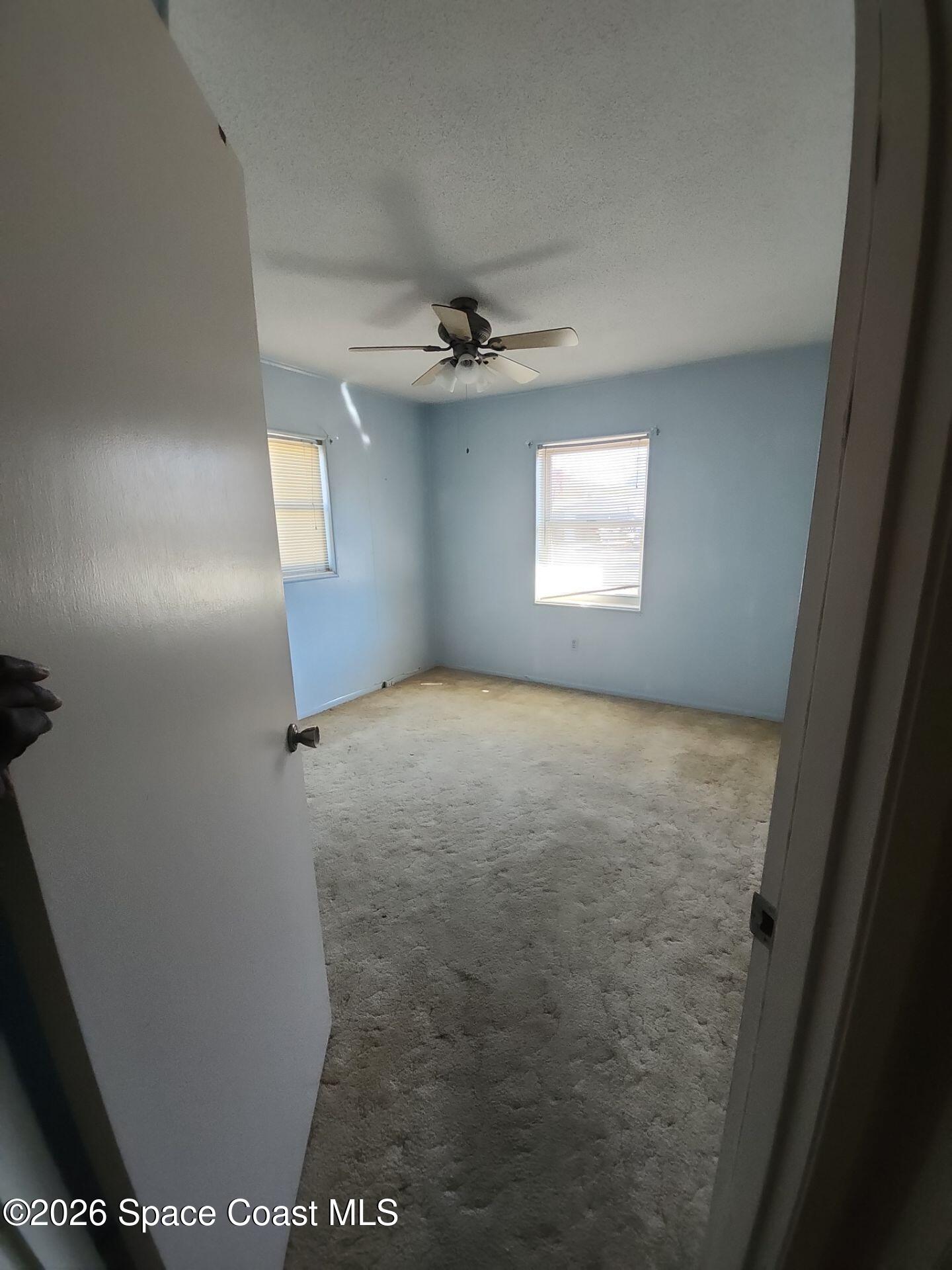 1654 Rice Avenue Titusville, FL 32796 - Photo 10 of 18 en empty room with windows and ceiling fan