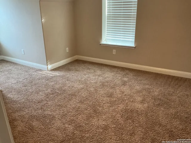 a view of an empty room with wooden floor and closet