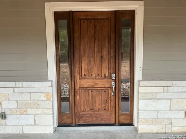 a kitchen with stainless steel appliances granite countertop a stove top oven a sink dishwasher a refrigerator and a dining table with wooden floor