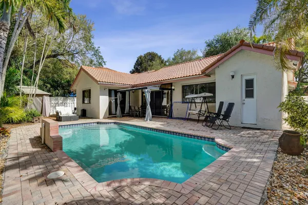 a view of a house with backyard sitting area and swimming pool