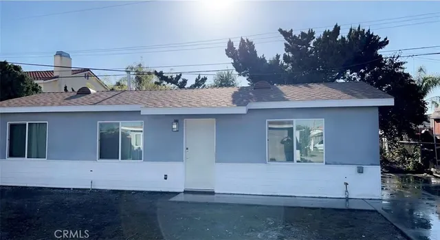 a view of a white house with a sink and a potted plant