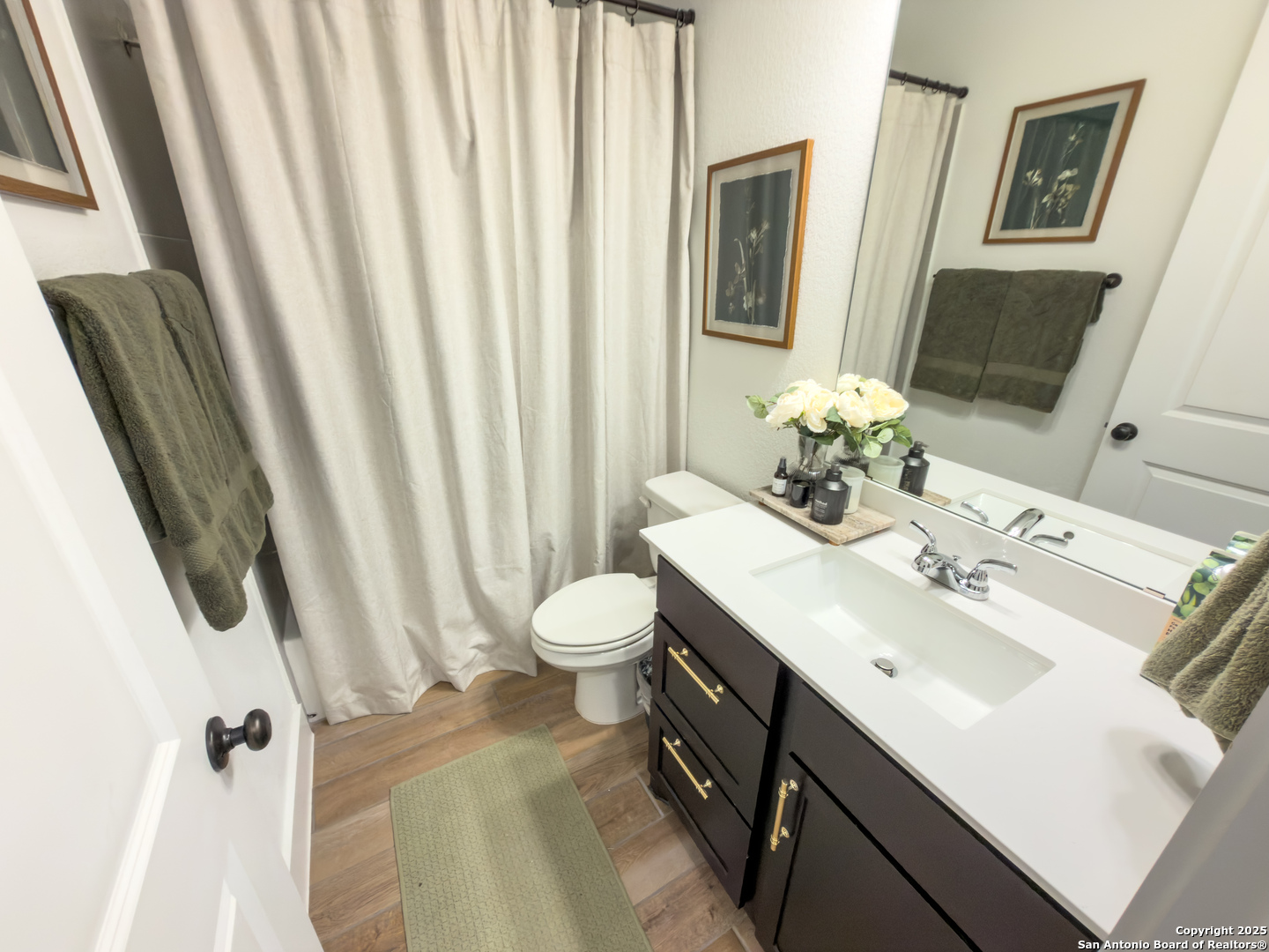 416 Kimble Creek Loop Kyle, TX 78640 - Photo 19 of 29 a bathroom with a sink a toilet and shower curtain
