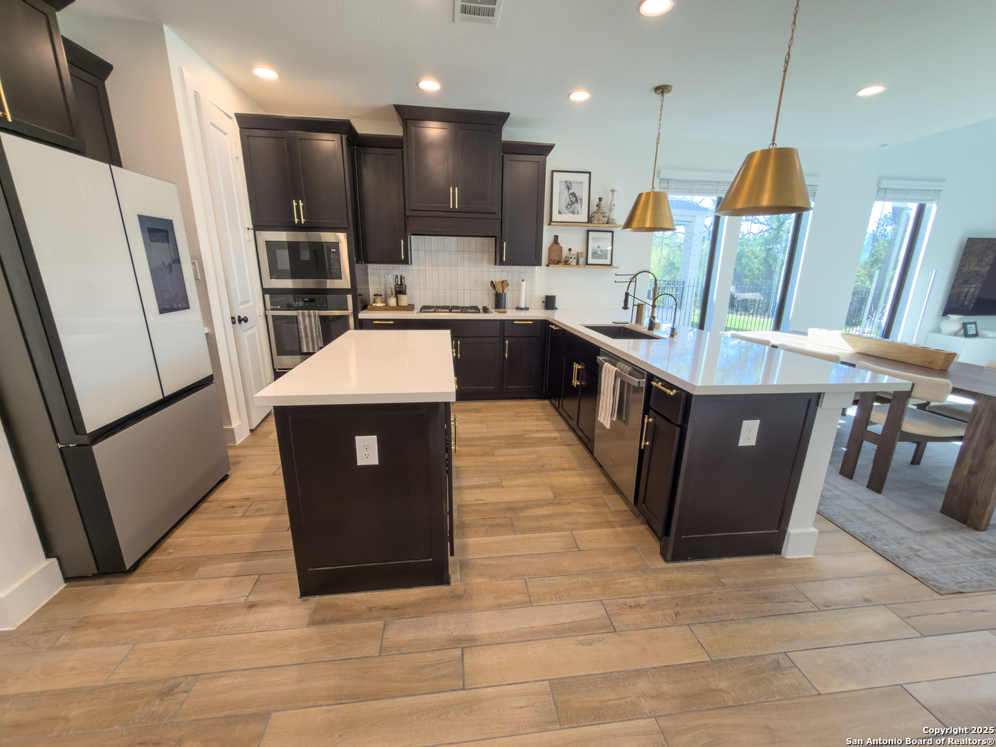 416 Kimble Creek Loop Kyle, TX 78640 - Photo 10 of 29 a large kitchen with stainless steel appliances kitchen island granite countertop a stove a refrigerator a sink and a counter top