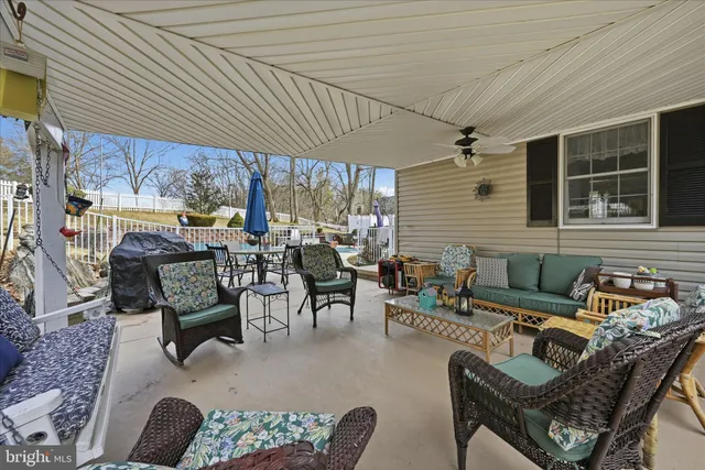 a backyard of a house with trees and outdoor seating