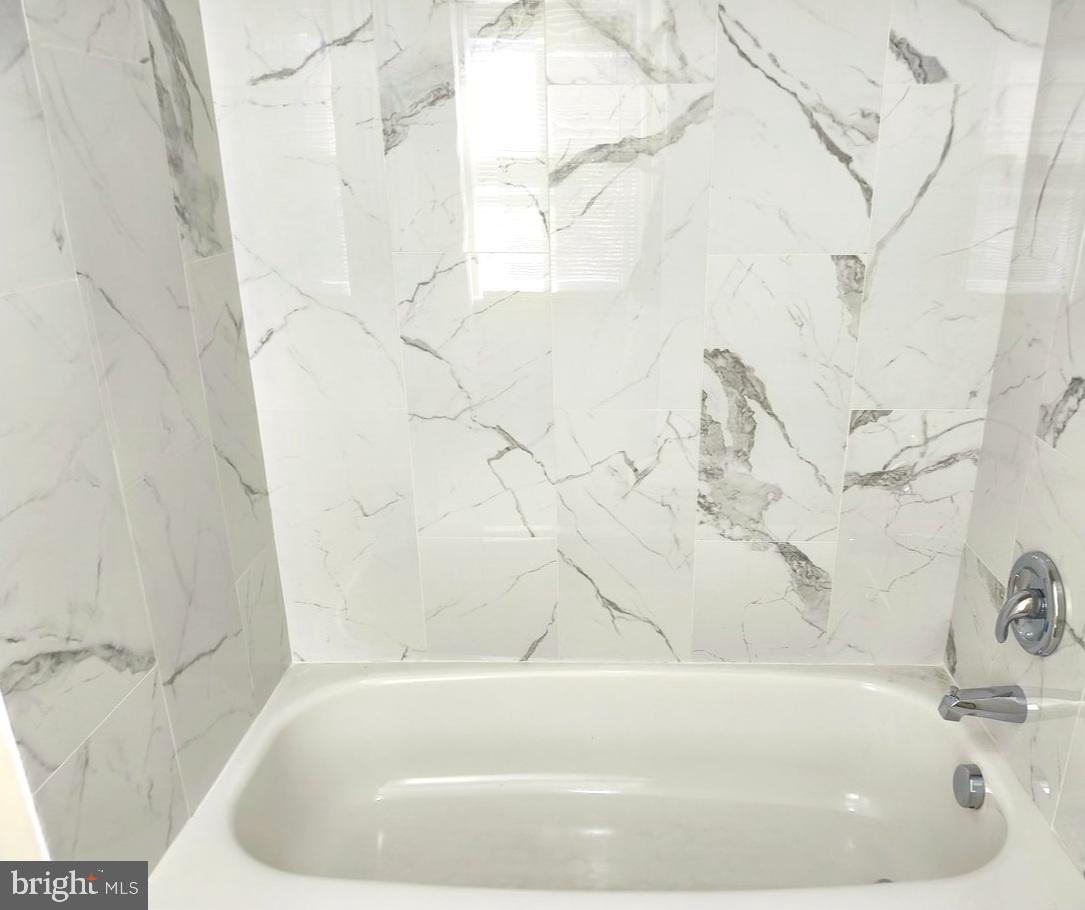 12452 Sweet Leaf Terrace Fairfax, VA 22033 - Photo 23 of 38 a white bath tub sitting in a bathroom
