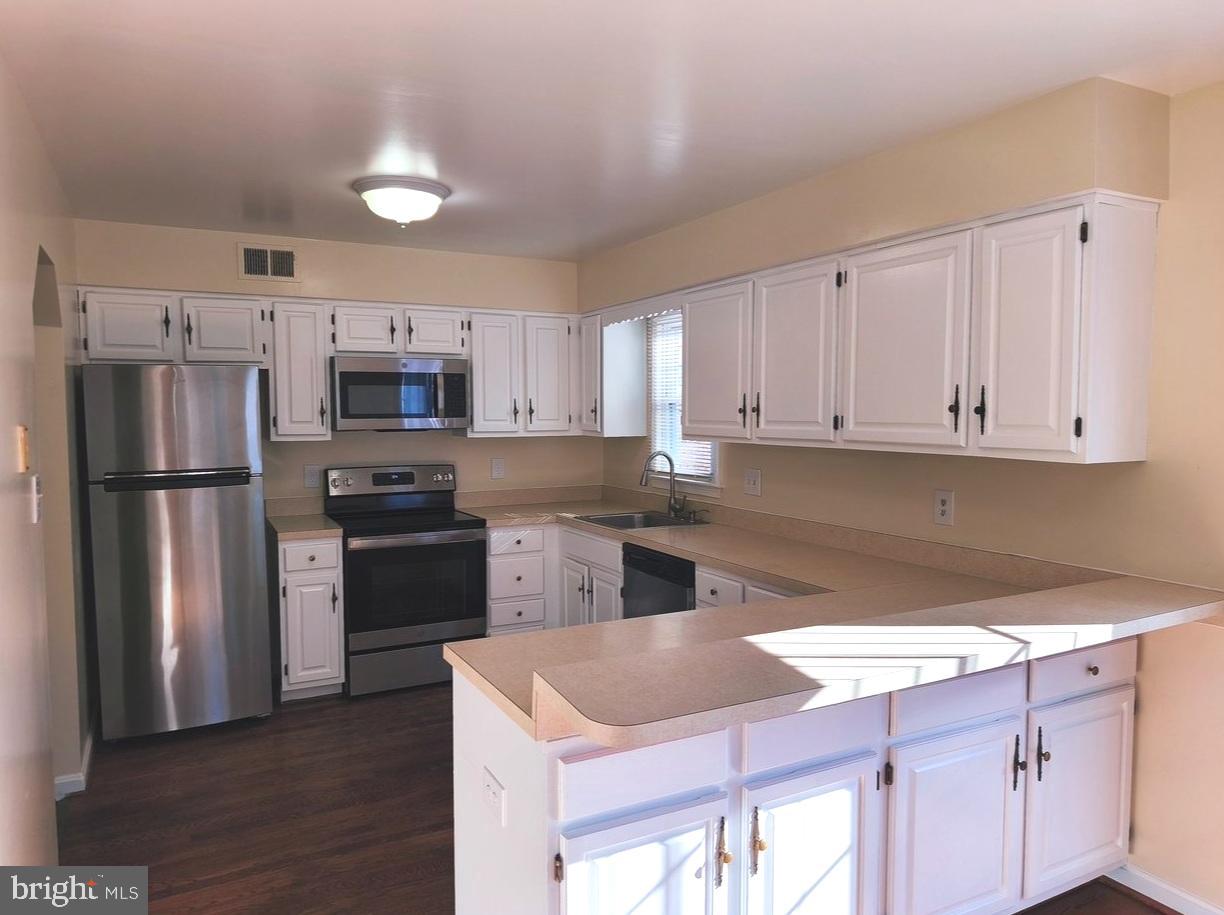 12452 Sweet Leaf Terrace Fairfax, VA 22033 - Photo 4 of 38 a kitchen with a refrigerator sink and cabinets