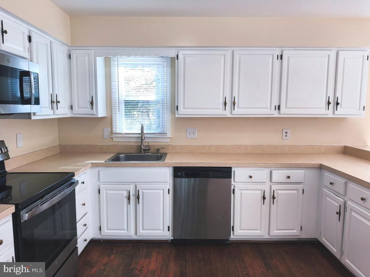 12452 Sweet Leaf Terrace Fairfax, VA 22033 - Photo 5 of 38 a kitchen with white cabinets white stainless steel appliances and sink