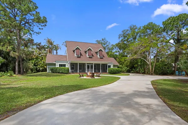 a view of a house with backyard sitting area and garden