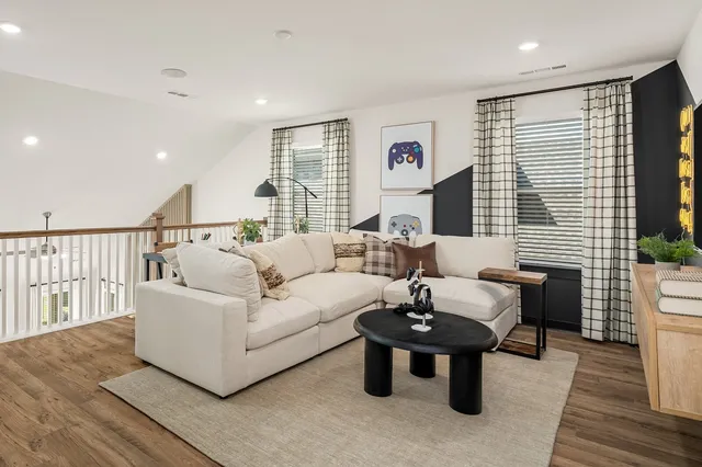a living room with furniture and a wooden floor
