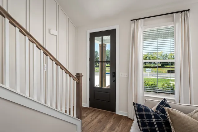 a view of a hallway with wooden floor and windows