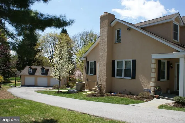 a front view of a house with a yard and tree