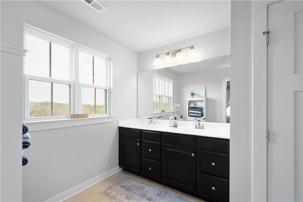 234 Regency Drive Eighty Four, PA 15330 - Photo 19 of 47 a bathroom with a double vanity sink and mirror with window