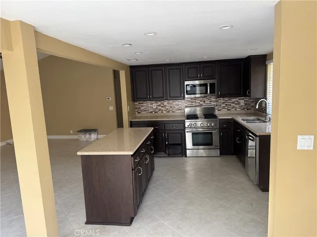 a kitchen with stainless steel appliances granite countertop a stove top oven sink and oven