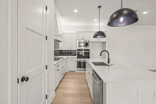 a kitchen with stainless steel appliances granite countertop a sink a stove and a refrigerator