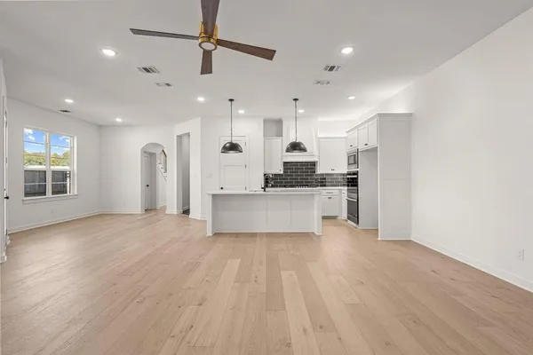 a large kitchen with cabinets and wooden floor
