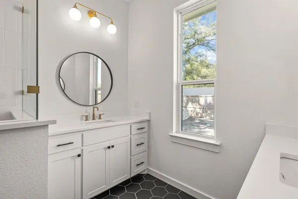 a bathroom with a sink a mirror and a window