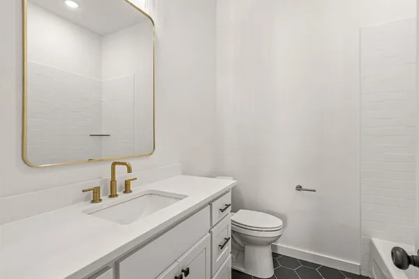 a bathroom with a sink a toilet and a mirror