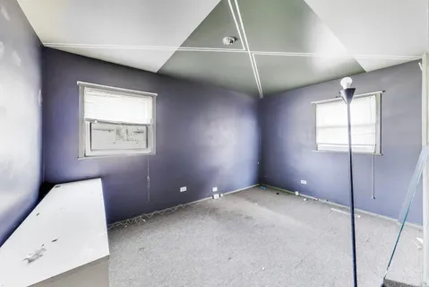 an empty room with windows and closet