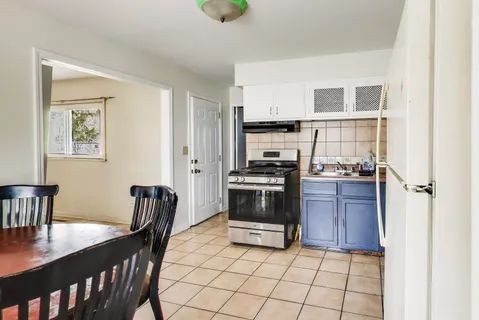 a kitchen with a stove a refrigerator and a dining table