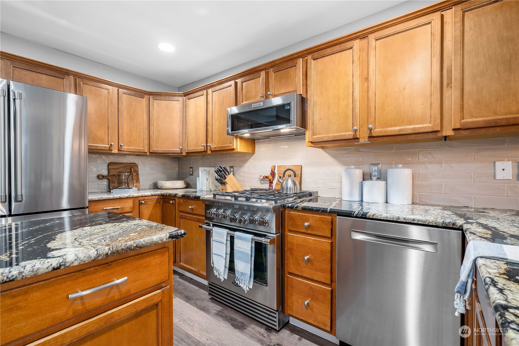 113 196th Place Southwest Bothell, WA 98012 - Photo 8 of 24 a kitchen with granite countertop stainless steel appliances a sink stove top oven and cabinets