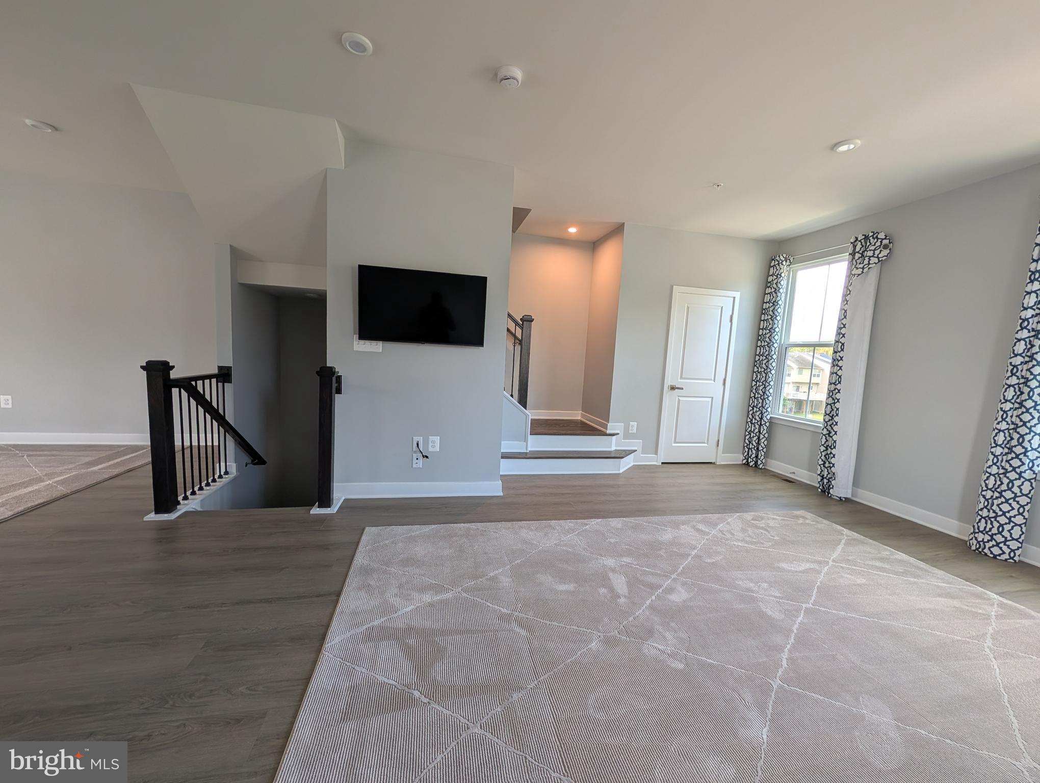 8445 Hamlin Street Lanham, MD 20706 - Photo 5 of 22 a view of a livingroom with wooden floor and a flat screen tv