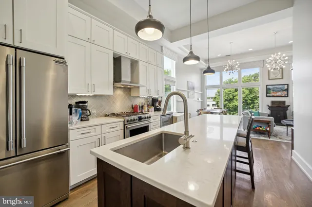 a kitchen with stainless steel appliances granite countertop a refrigerator a stove a sink dishwasher a refrigerator white cabinets and wooden floor