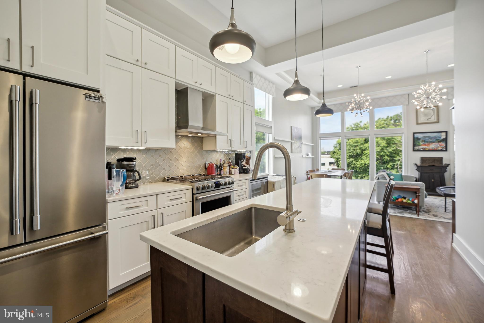 3815 14th Street Northwest, Unit 6 Washington, DC 20011 - Photo 4 of 15 a kitchen with stainless steel appliances granite countertop a refrigerator a stove a sink dishwasher a refrigerator white cabinets and wooden floor