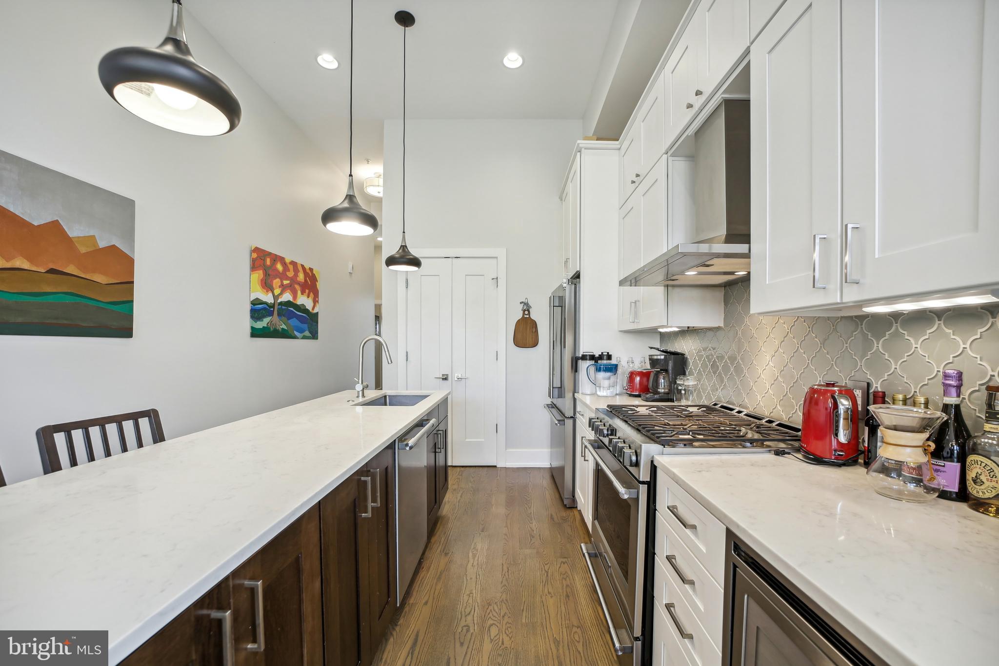 3815 14th Street Northwest, Unit 6 Washington, DC 20011 - Photo 5 of 15 a kitchen with stainless steel appliances a sink a stove a refrigerator a center island and cabinets