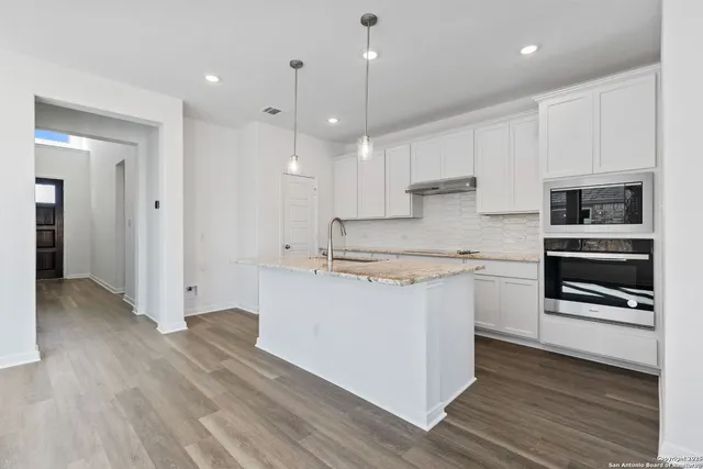 a kitchen with stainless steel appliances granite countertop a stove a sink and a refrigerator