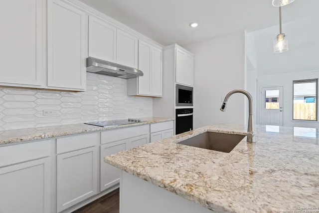 a kitchen with kitchen island a sink stainless steel appliances and cabinets