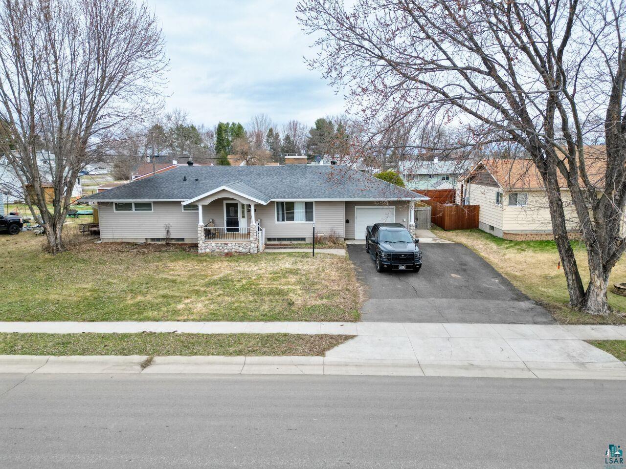 Ranch-style residence featuring a covered front entry with stacked stone accents