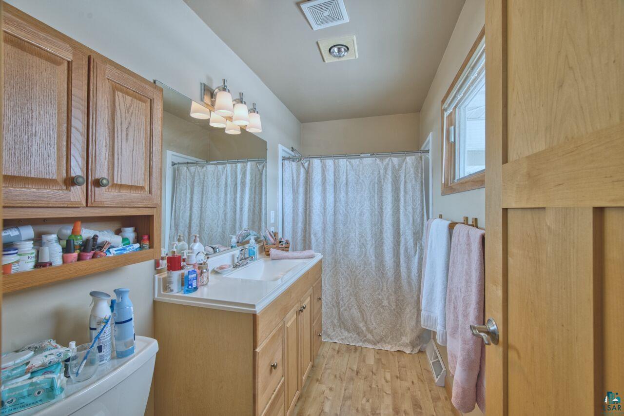 203 Wyandotte Road Hoyt Lakes, MN 55750 - Photo 18 of 39 Bathroom with vanity, a shower with curtain, and light wood finished floors