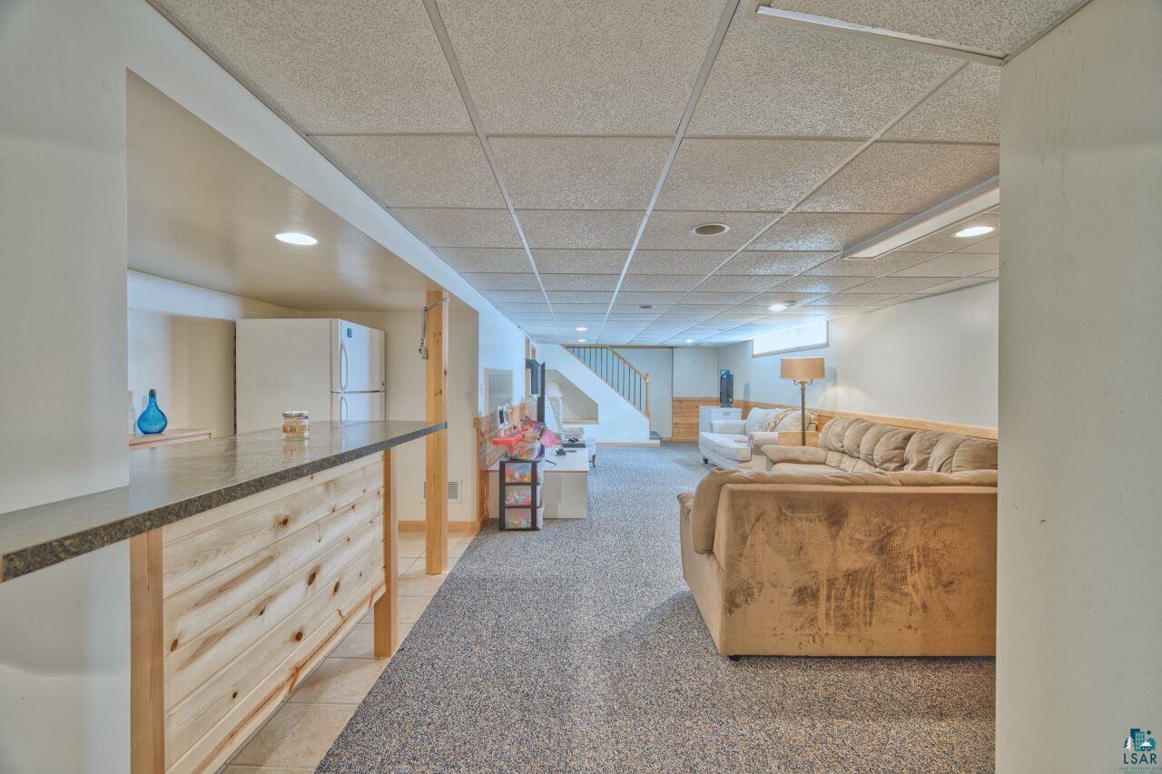 203 Wyandotte Road Hoyt Lakes, MN 55750 - Photo 23 of 39 Living area featuring a drop ceiling, light tile patterned flooring, and light colored carpet