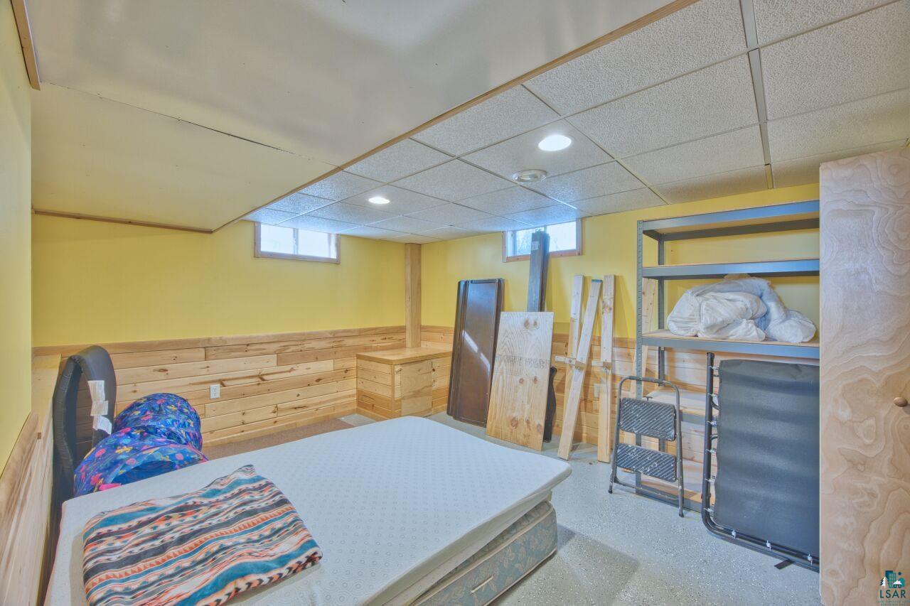 203 Wyandotte Road Hoyt Lakes, MN 55750 - Photo 24 of 39 Bedroom featuring a drop ceiling, wood walls, recessed lighting, and a wainscoted wall