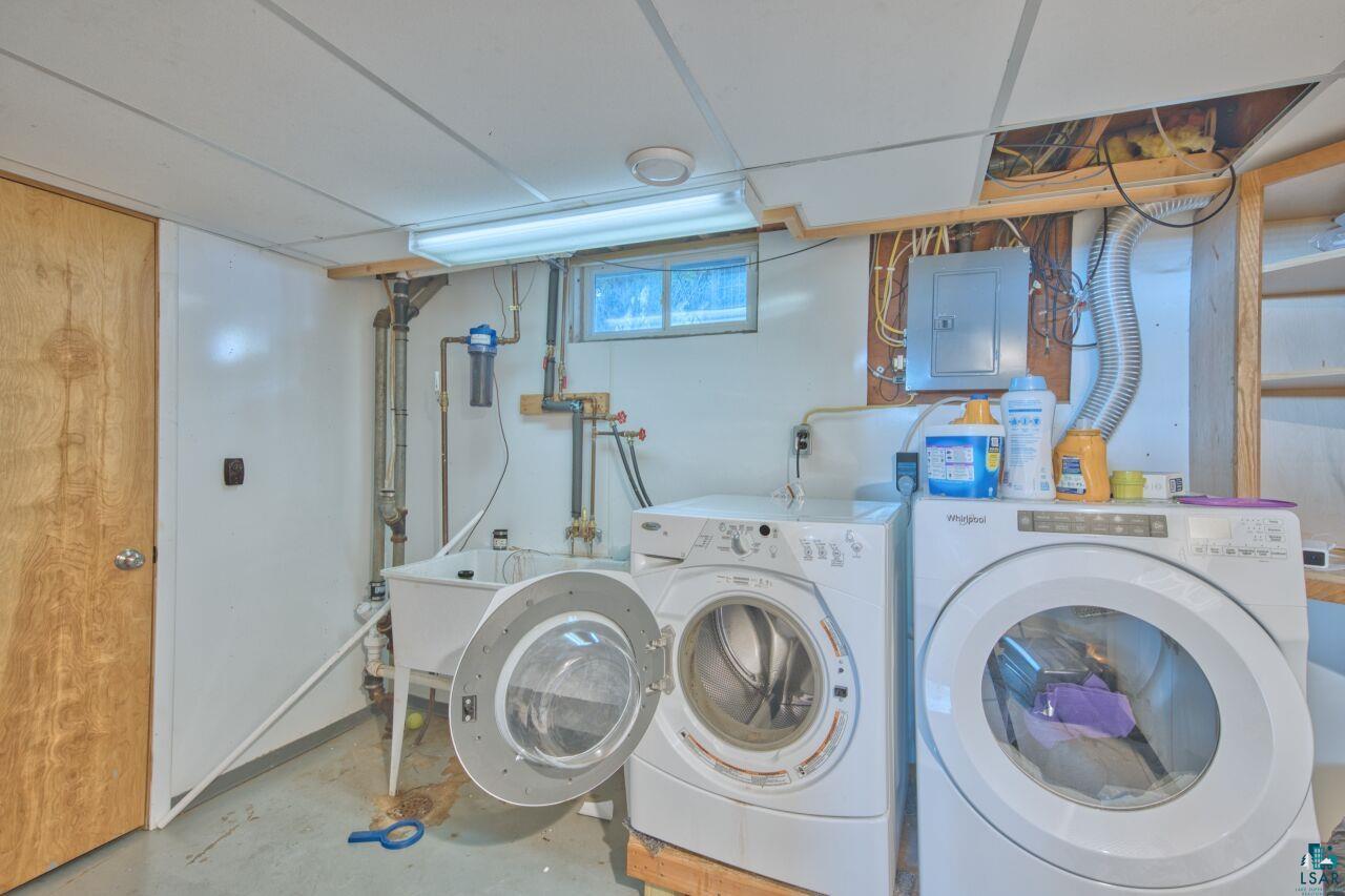 203 Wyandotte Road Hoyt Lakes, MN 55750 - Photo 28 of 44 Laundry area featuring unfinished concrete floors, electric panel, and washing machine and clothes dryer