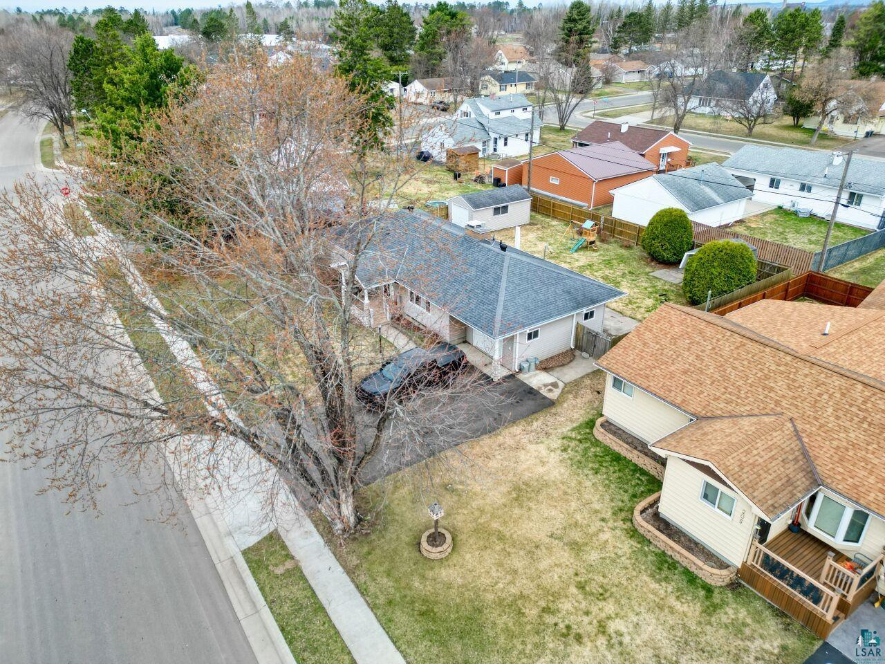 203 Wyandotte Road Hoyt Lakes, MN 55750 - Photo 37 of 39 Property featuring a gray shingle roof, a paved driveway, and a front porch with white columns