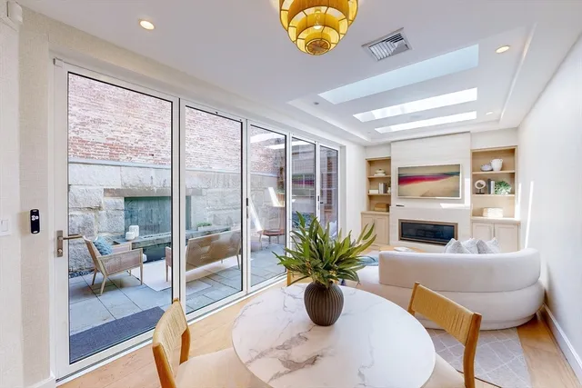 a view of a dining room with furniture a potted plant and a chandelier