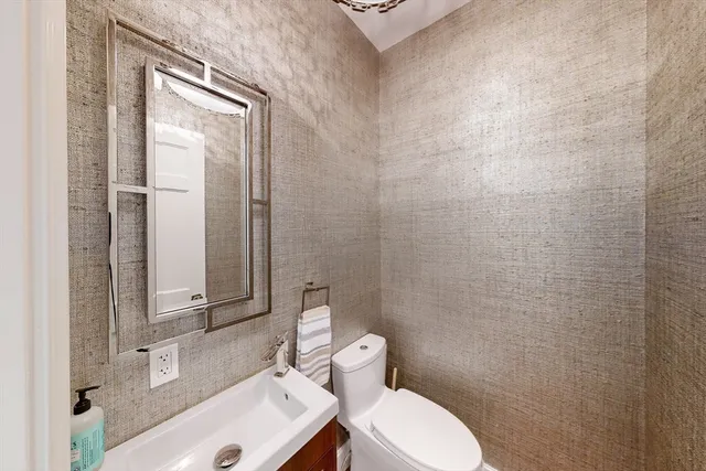 a bathroom with a toilet a sink and mirror