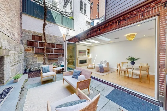a view of a patio with couches table and chairs and potted plants